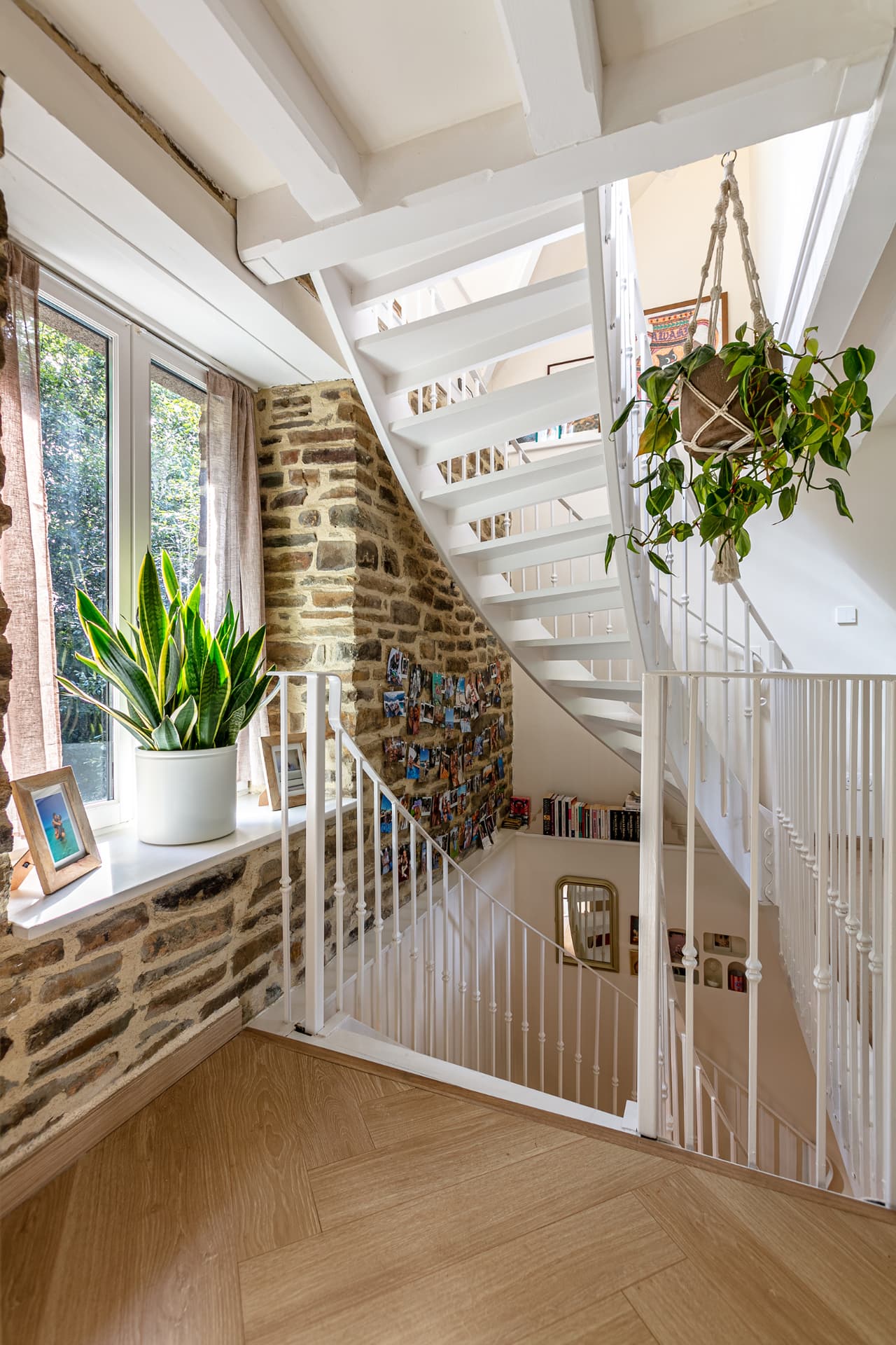 Stairwell with old stone walls, plants and a window onto the trees