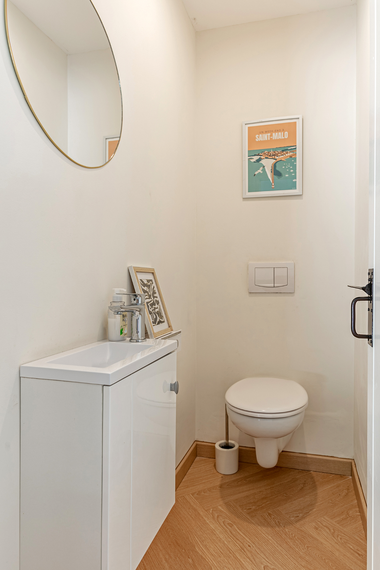 Ground-floor WC with round brass mirror and Saint-Malo print