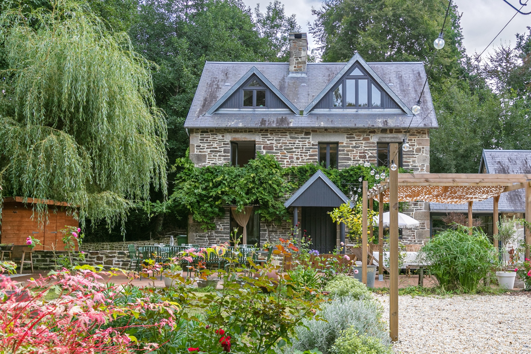 Stone house seen through the colourful garden beds