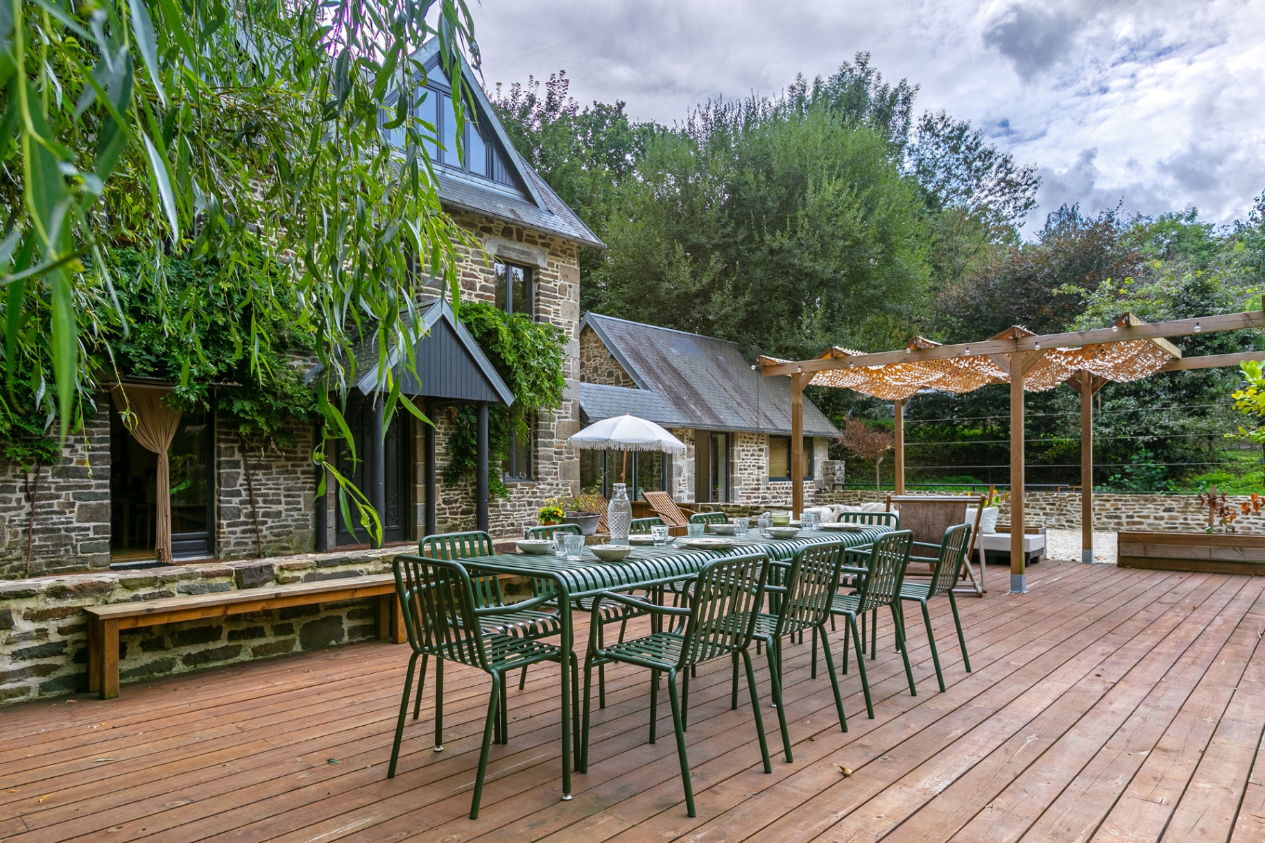 Long outdoor table beside the stone house and pergola