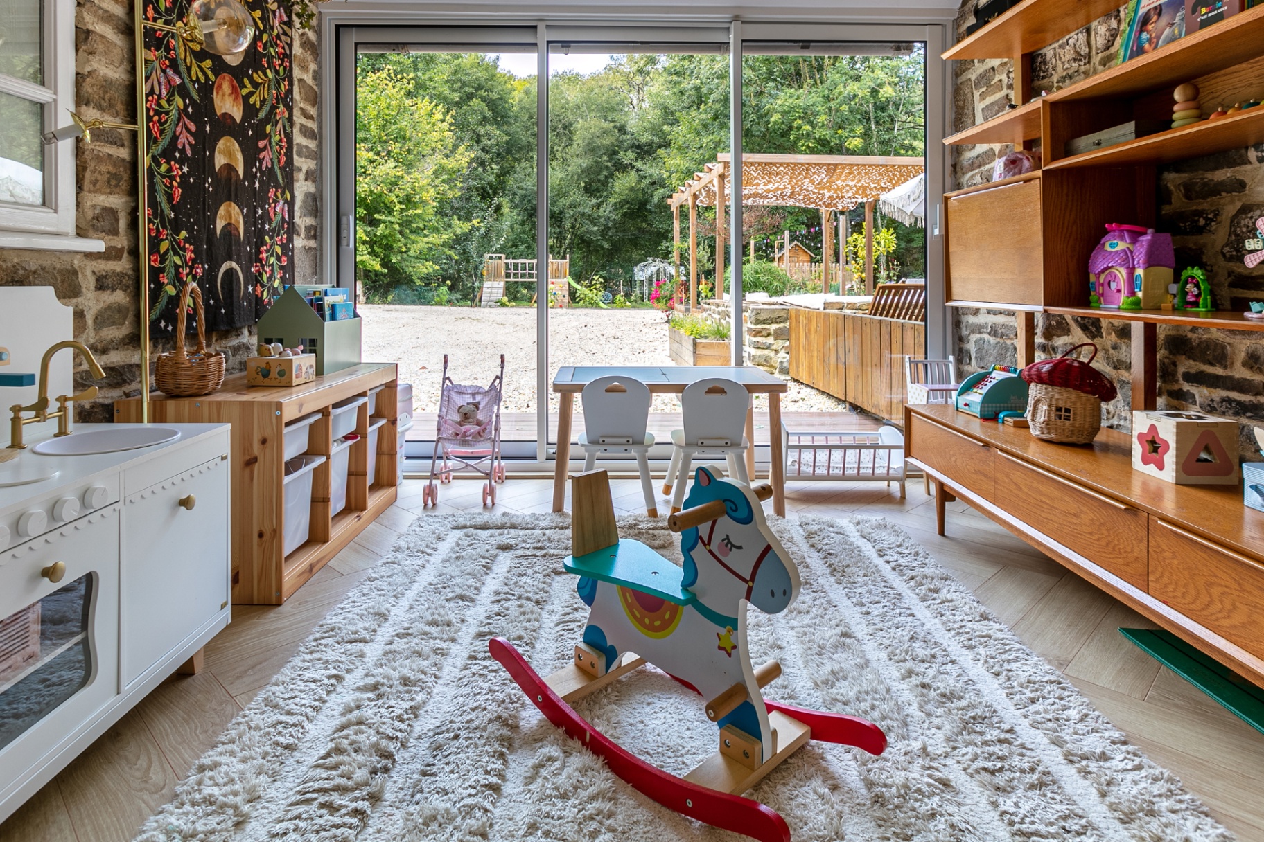 Playroom with rocking horse and open glass doors onto the garden