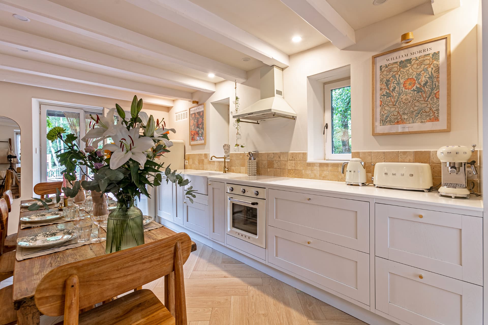 Kitchen with cream oven, travertine tiles and doors to the garden