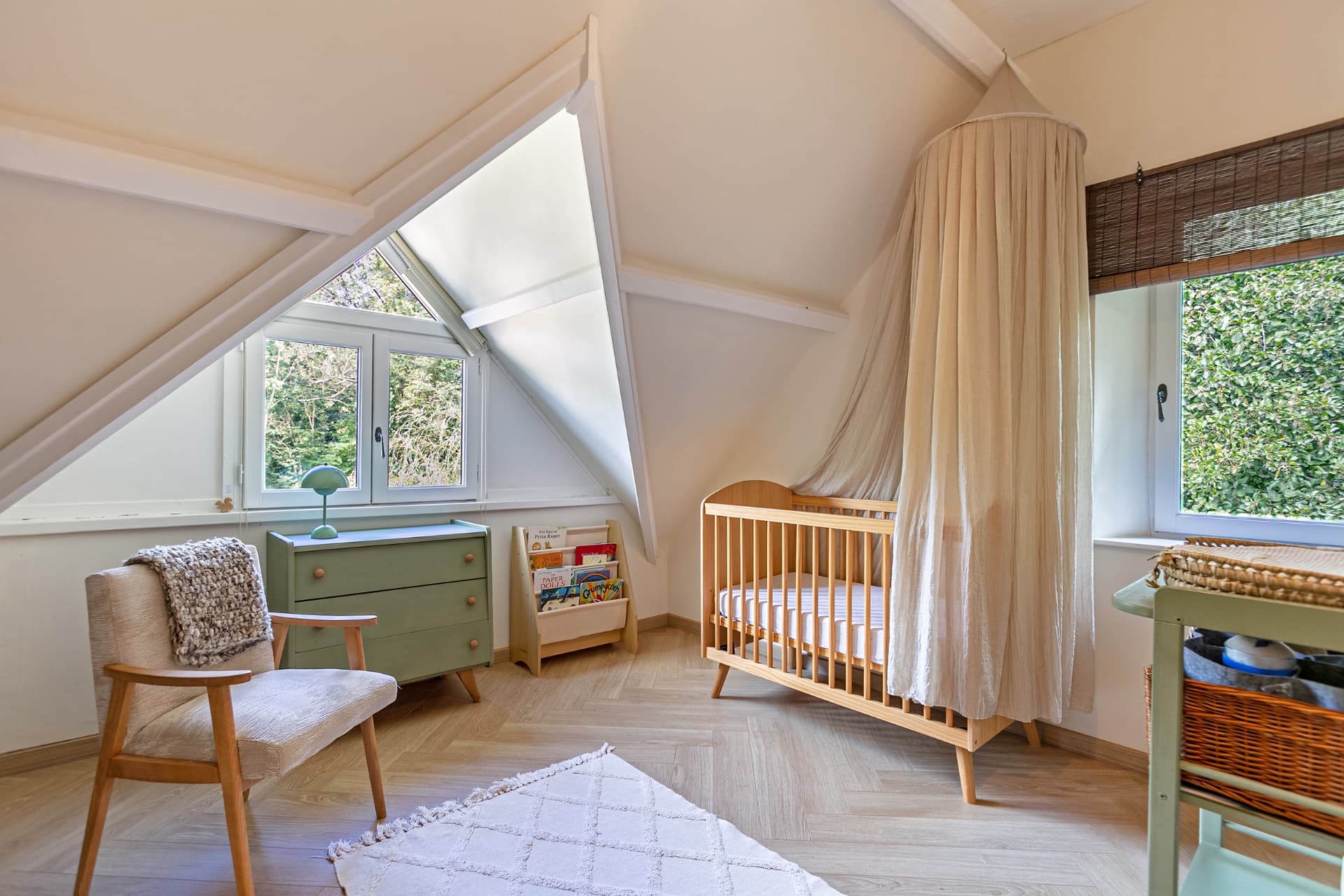 Nursery with wooden cot and window onto greenery