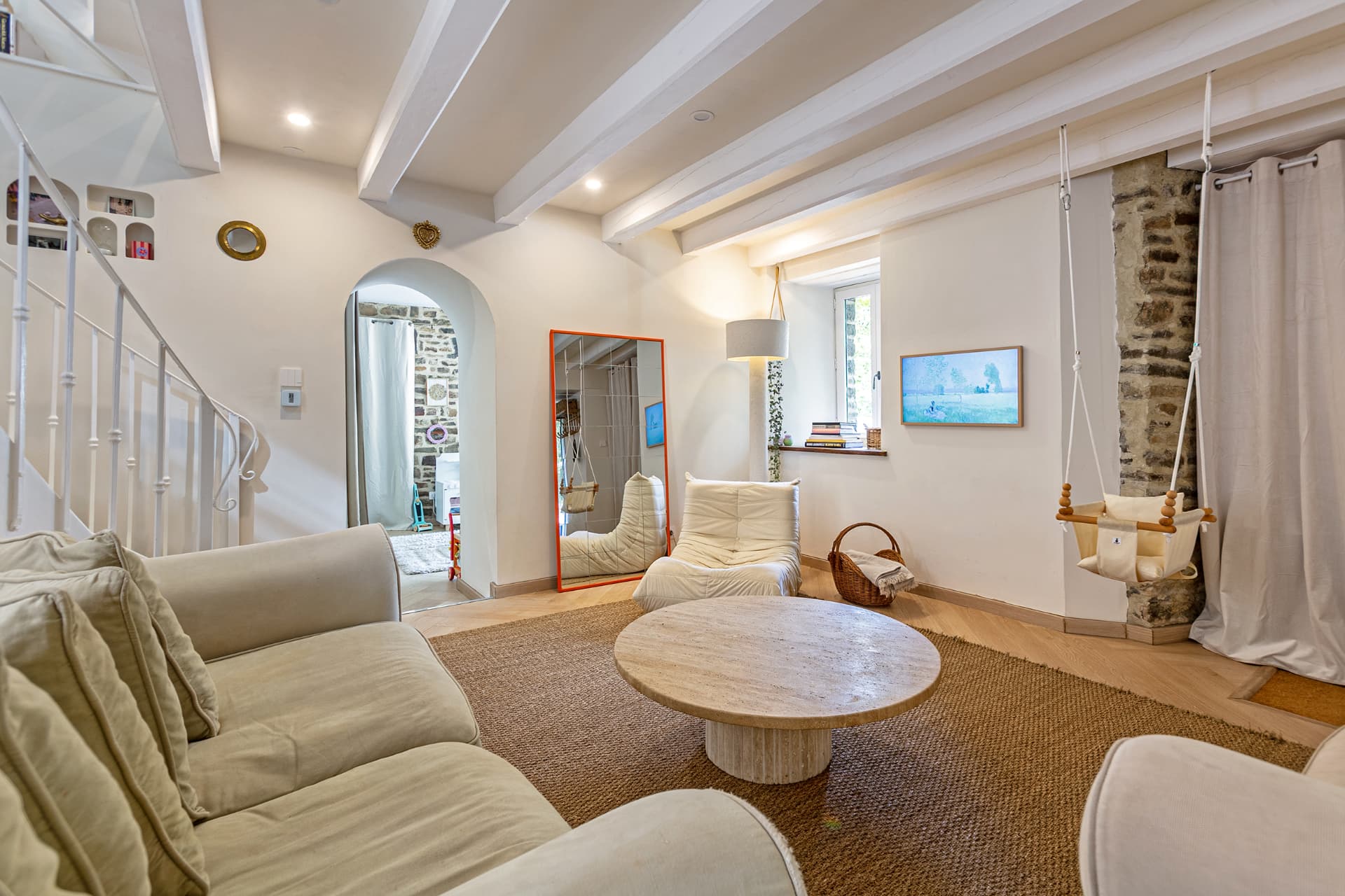 Living room with baby swing beside an old stone pillar