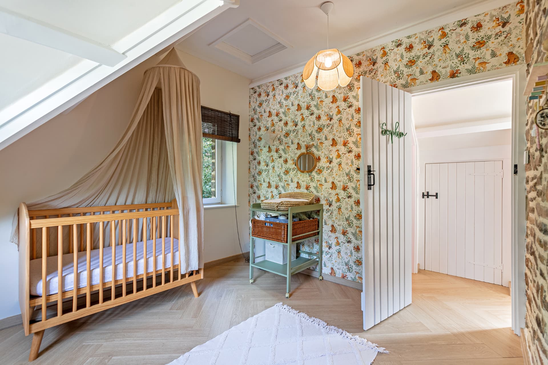 Nursery with woodland animal wallpaper and cot