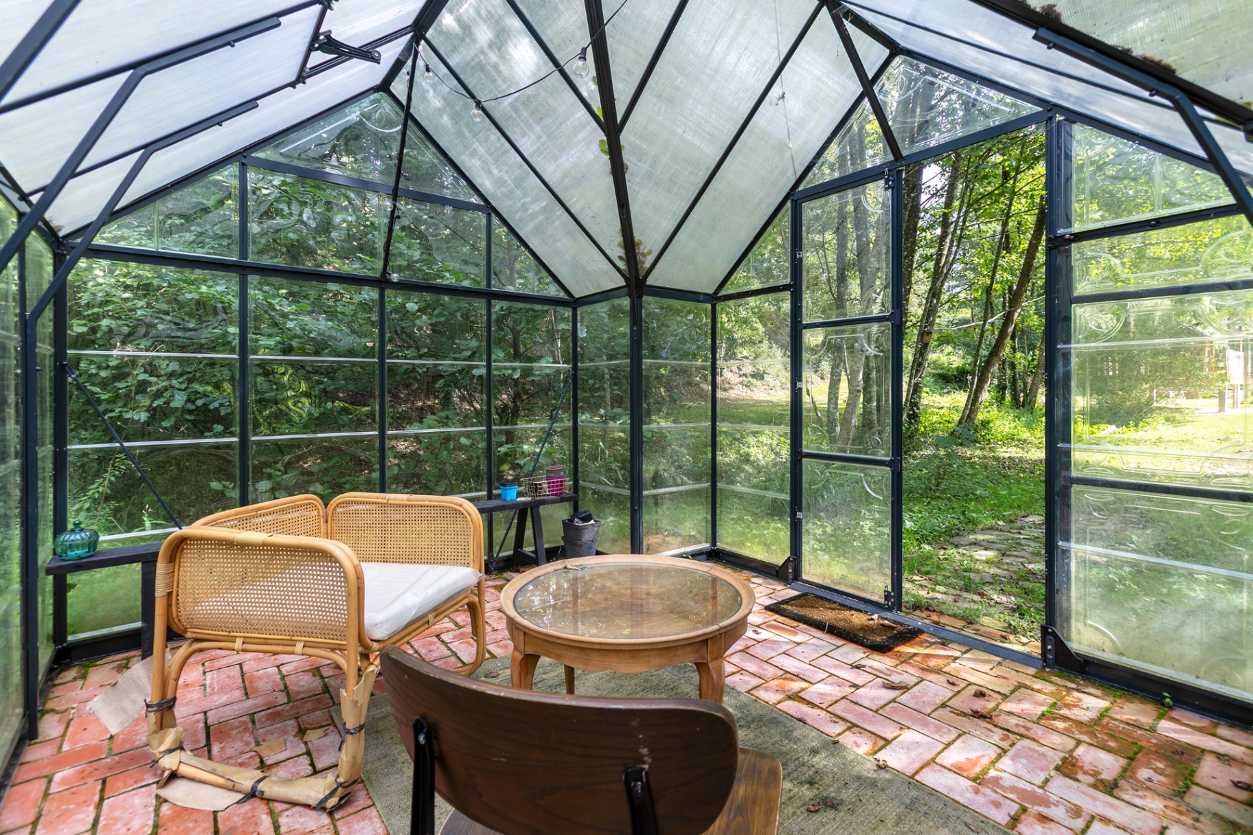 Rattan chair and round table inside the greenhouse