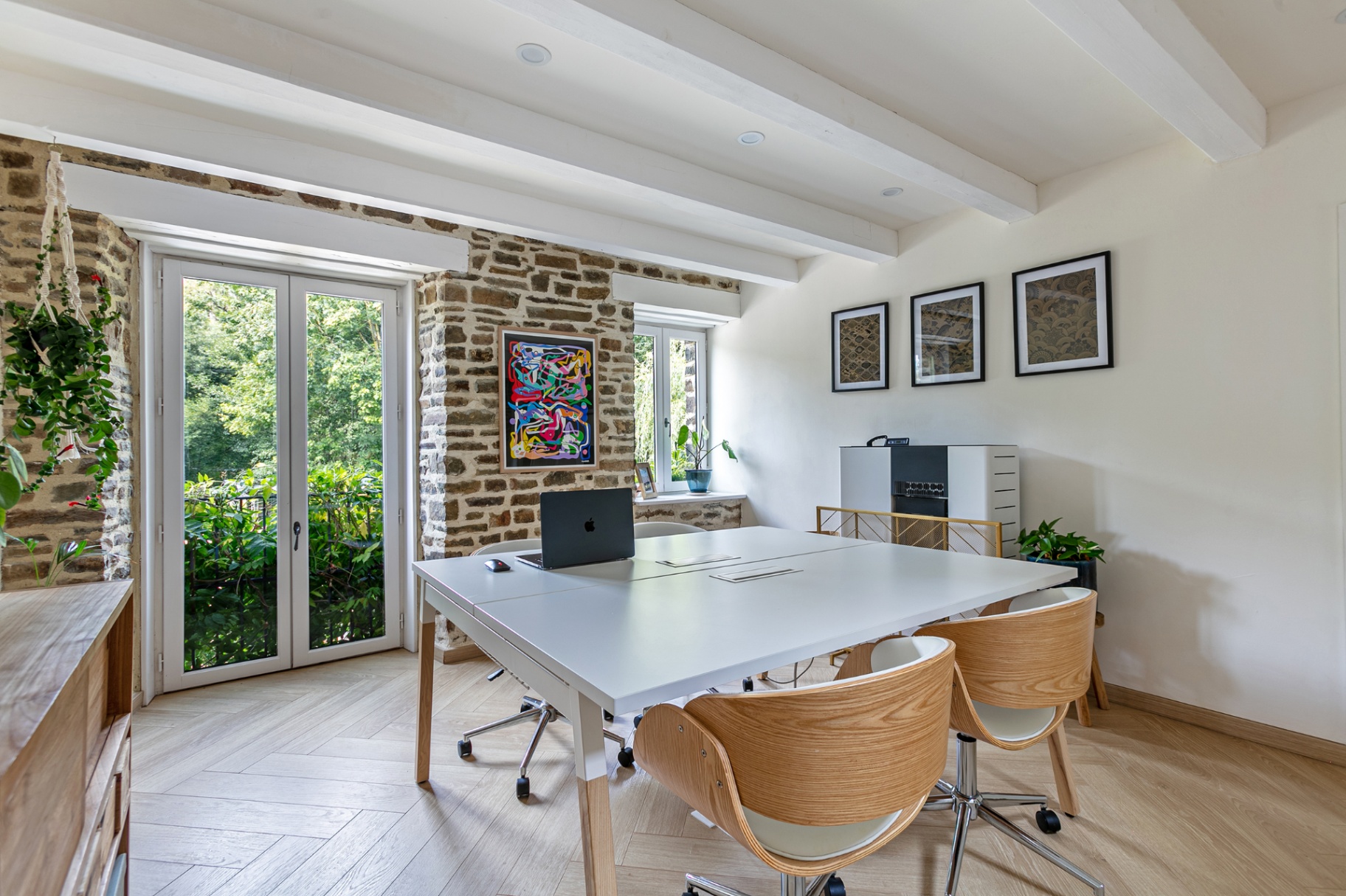 Shared workspace with four chairs and doors onto the garden