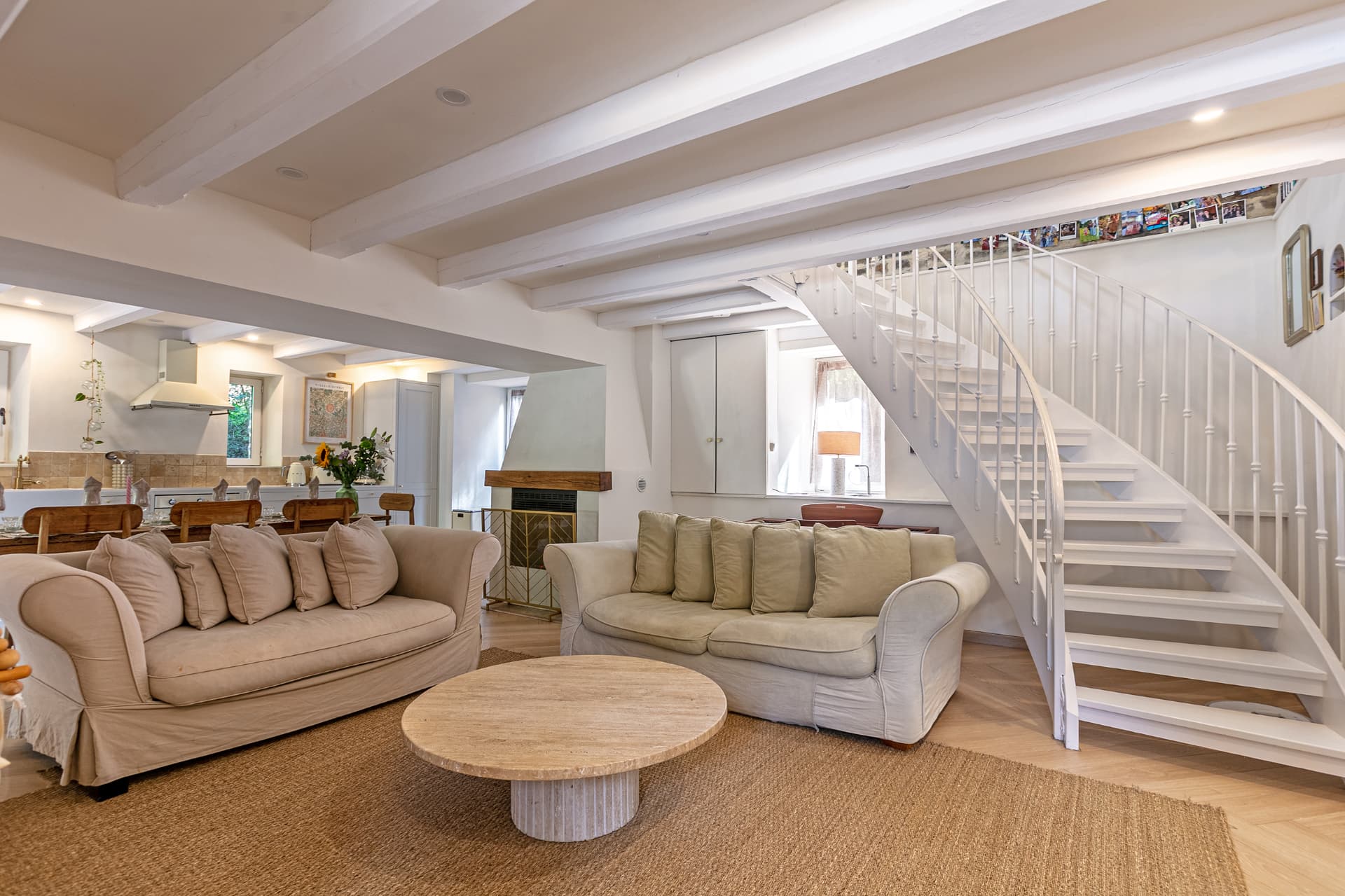 Sofas by the fireplace with the kitchen and dining table behind