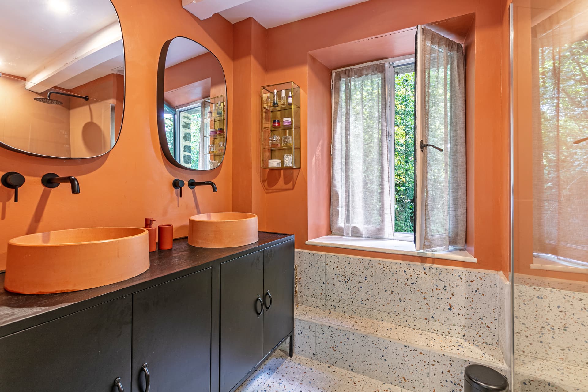 Terracotta en-suite with twin basins and a window to the garden