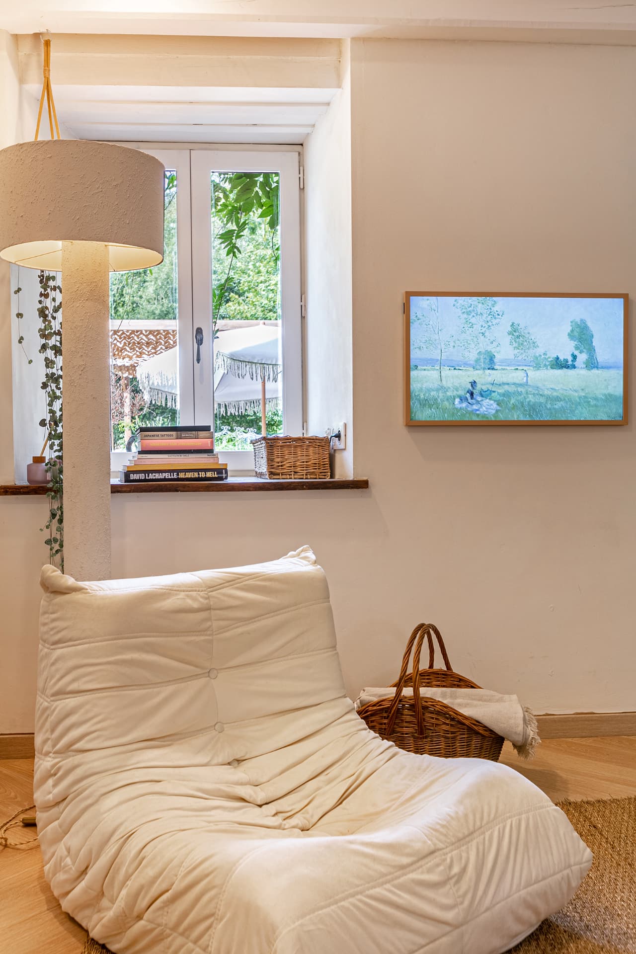 Floor chair and books beneath a window onto the garden