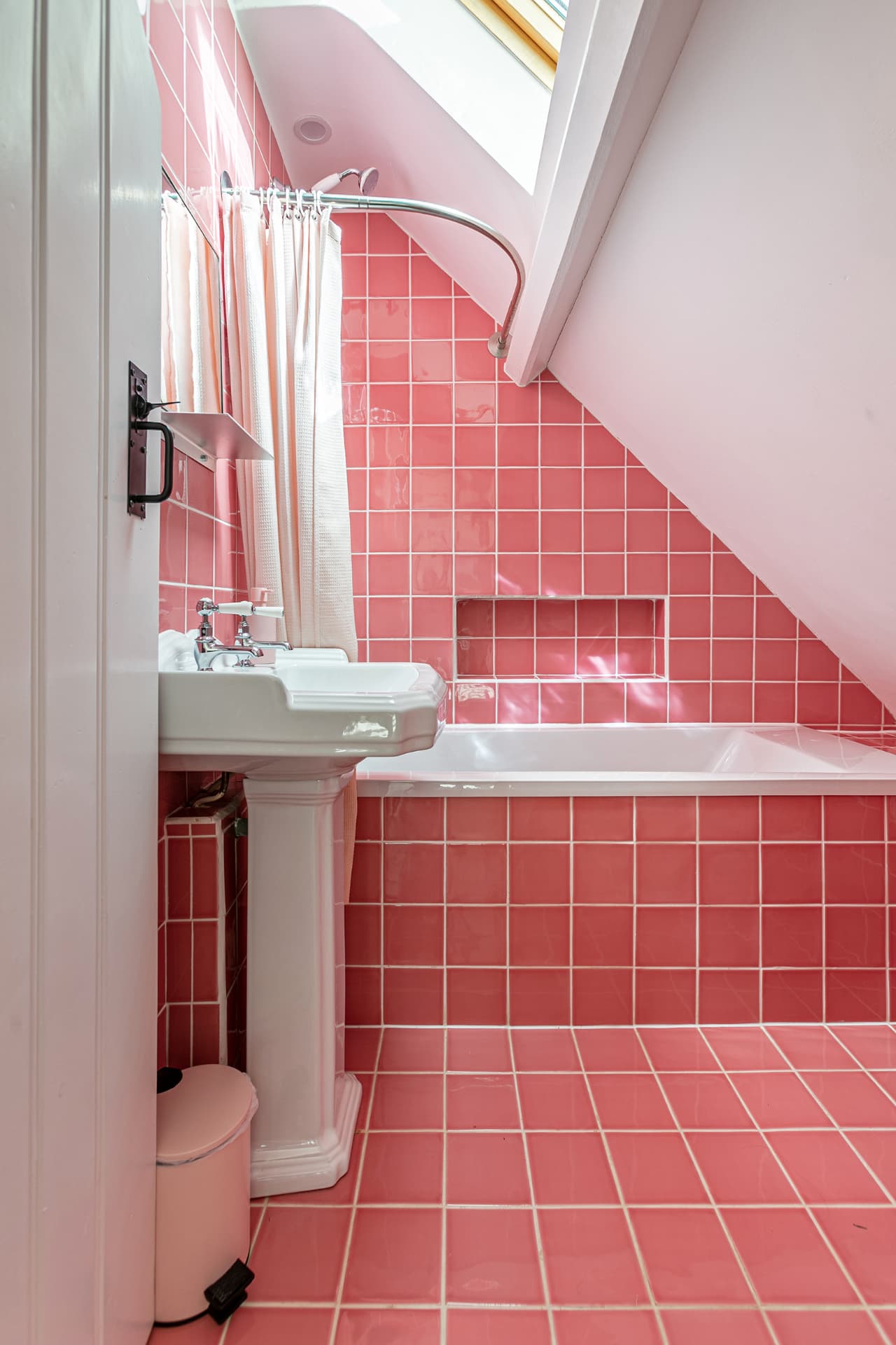 Bath and pedestal basin beneath a skylight