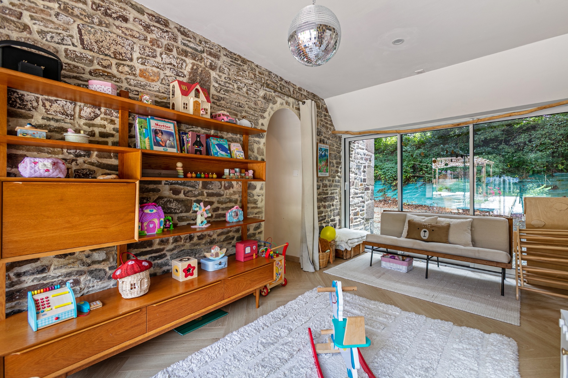 Playroom with vintage bookshelves, toys and stone walls