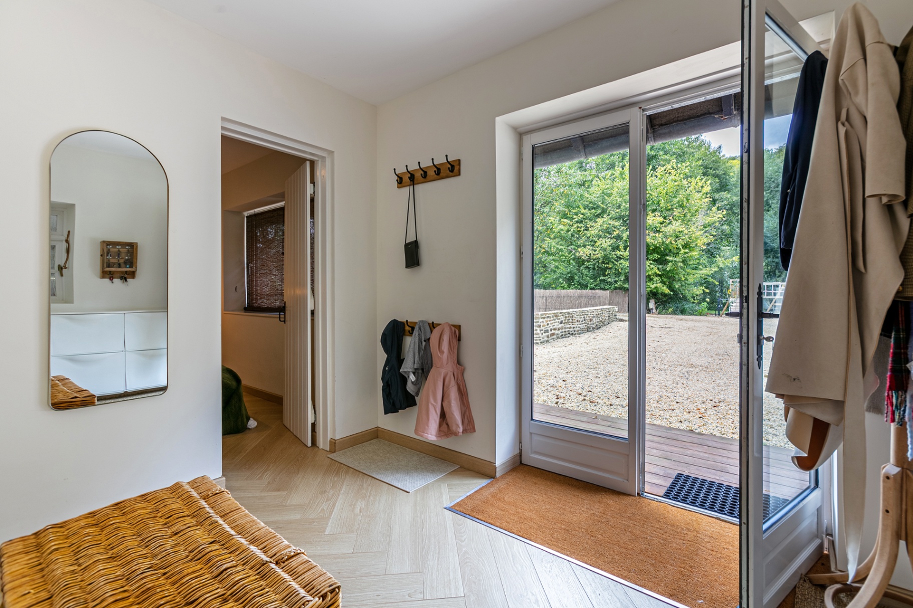 Entrance with glass doors open onto the deck and woods