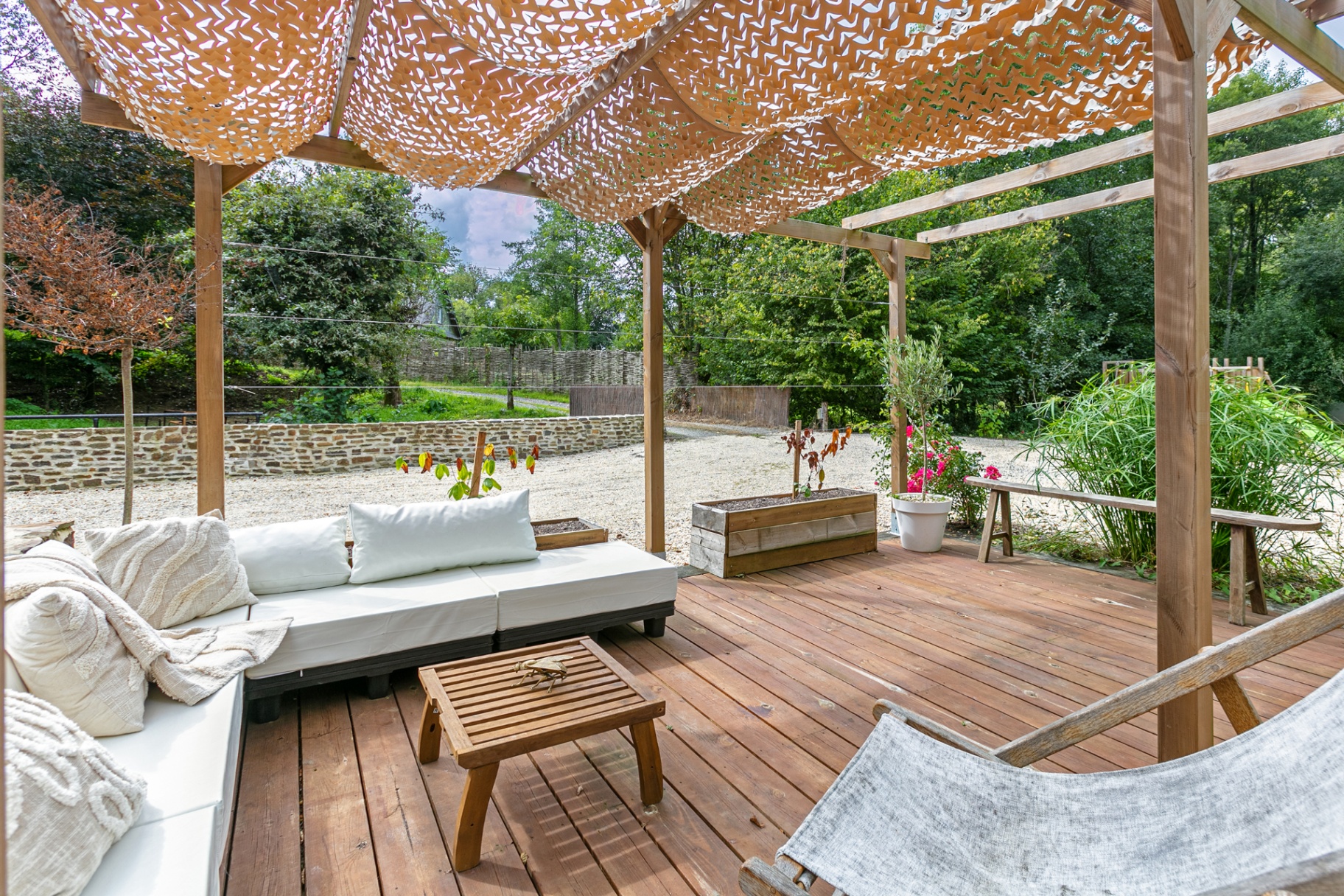 Pergola lounge looking out over the garden and stone wall