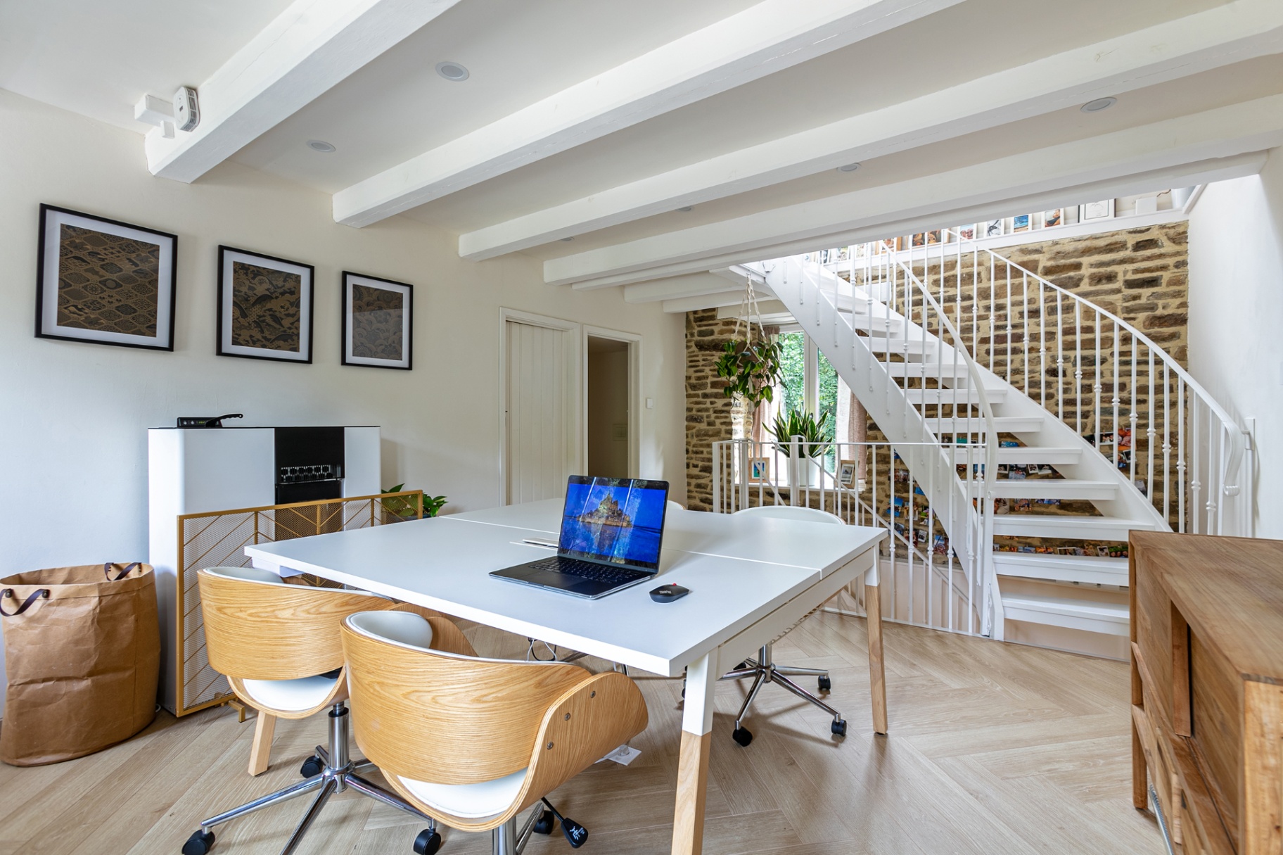 Coworking table beside the white staircase and stone wall