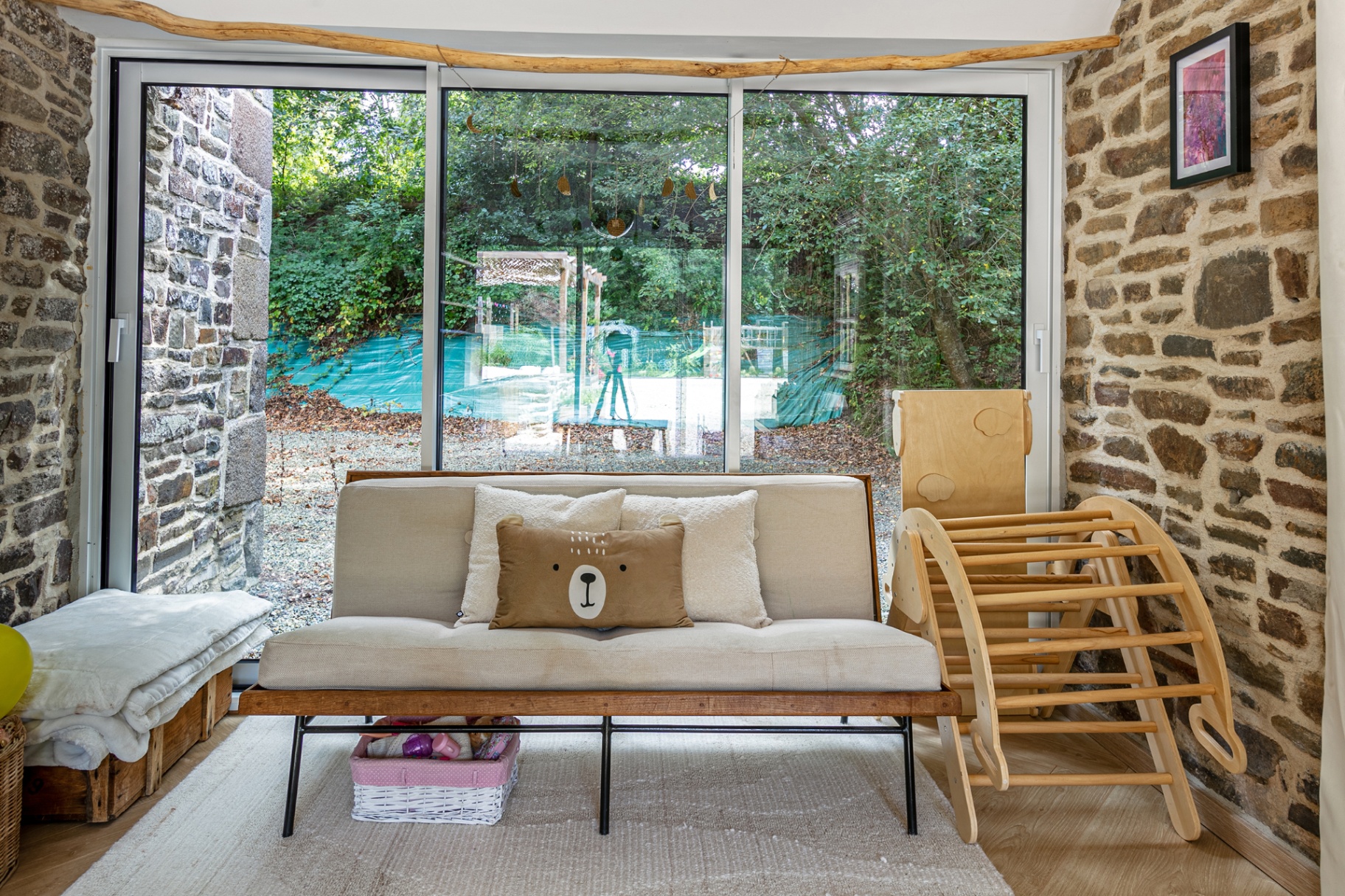 Sofa in front of floor-to-ceiling windows onto the woods